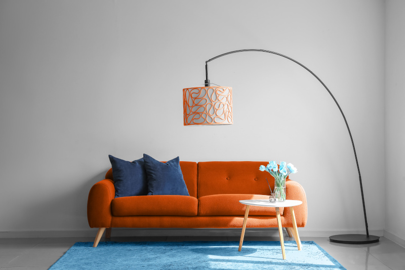 Orangefarbenes Sofa mit blauen Kissen